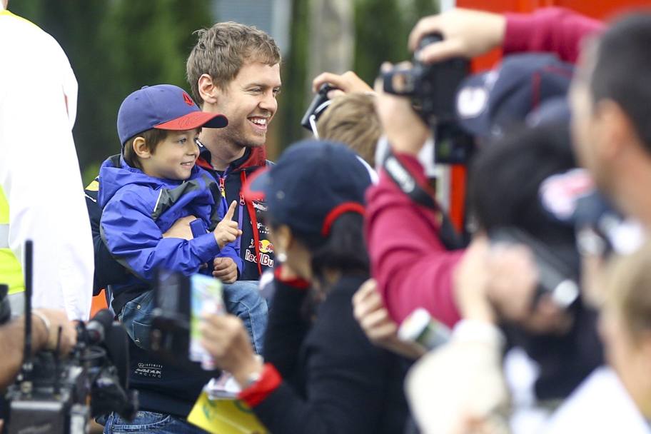 Vettel regala un bel ricordo a un bambino. Epa